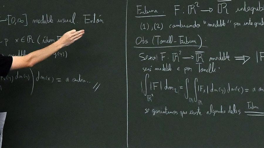 Detalle dunha man escribindo nunha pizarra