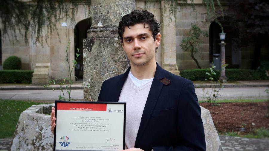 O doutorando Hernán Cortez posando co premio do Grupo Compostela